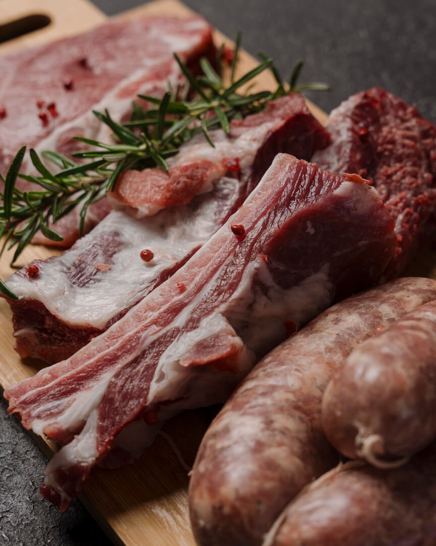 Costine di maiale fresche con salsicce su tagliere Carlo Poma