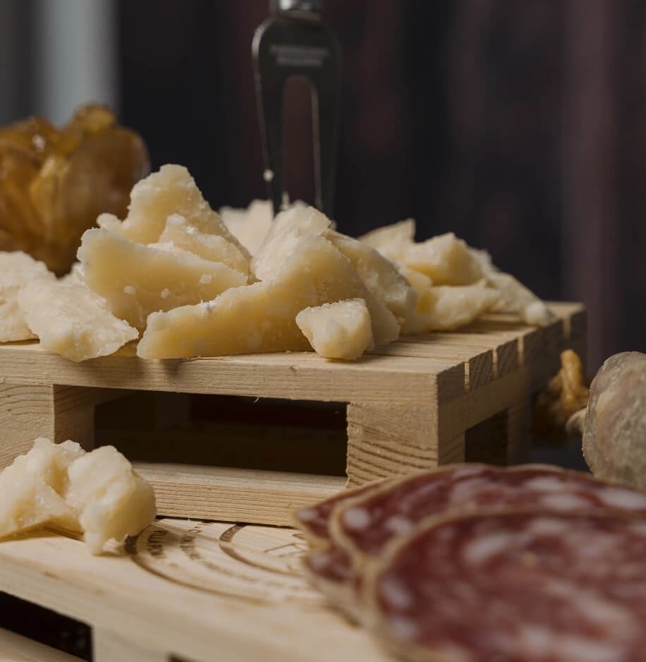 Scaglie di Parmigiano Reggiano e salame su tagliere di legno