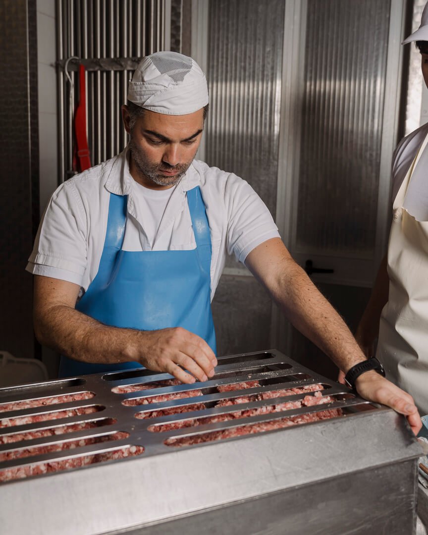 Macellaio prepara insaccati con carne macinata in laboratorio