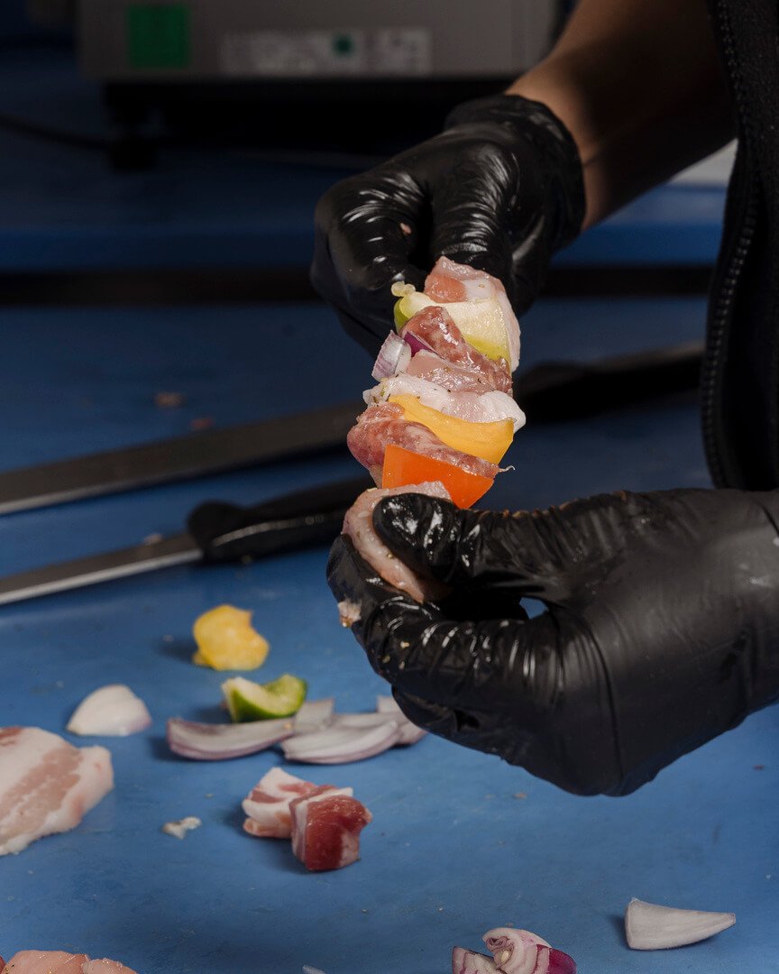 Addetto prepara spiedino di carne mista con verdure Carlo Poma