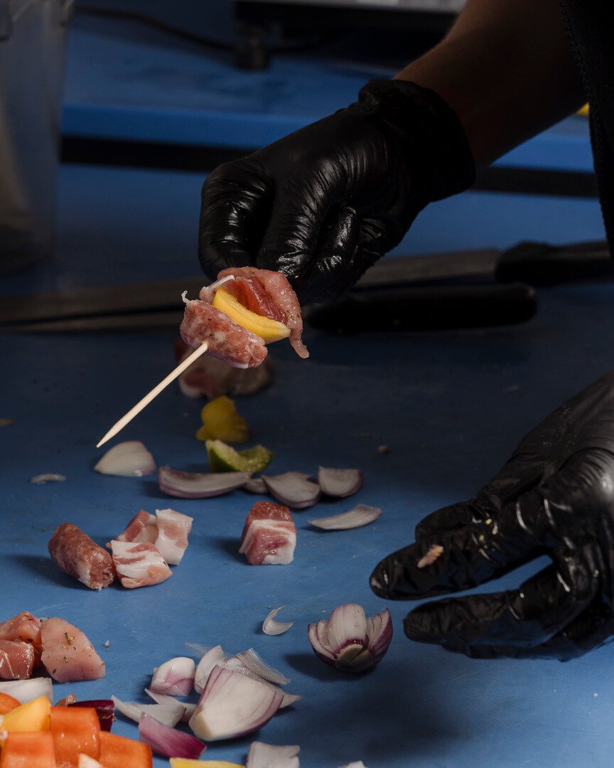 Addetto prepara spiedino di carne e verdure Carlo Poma