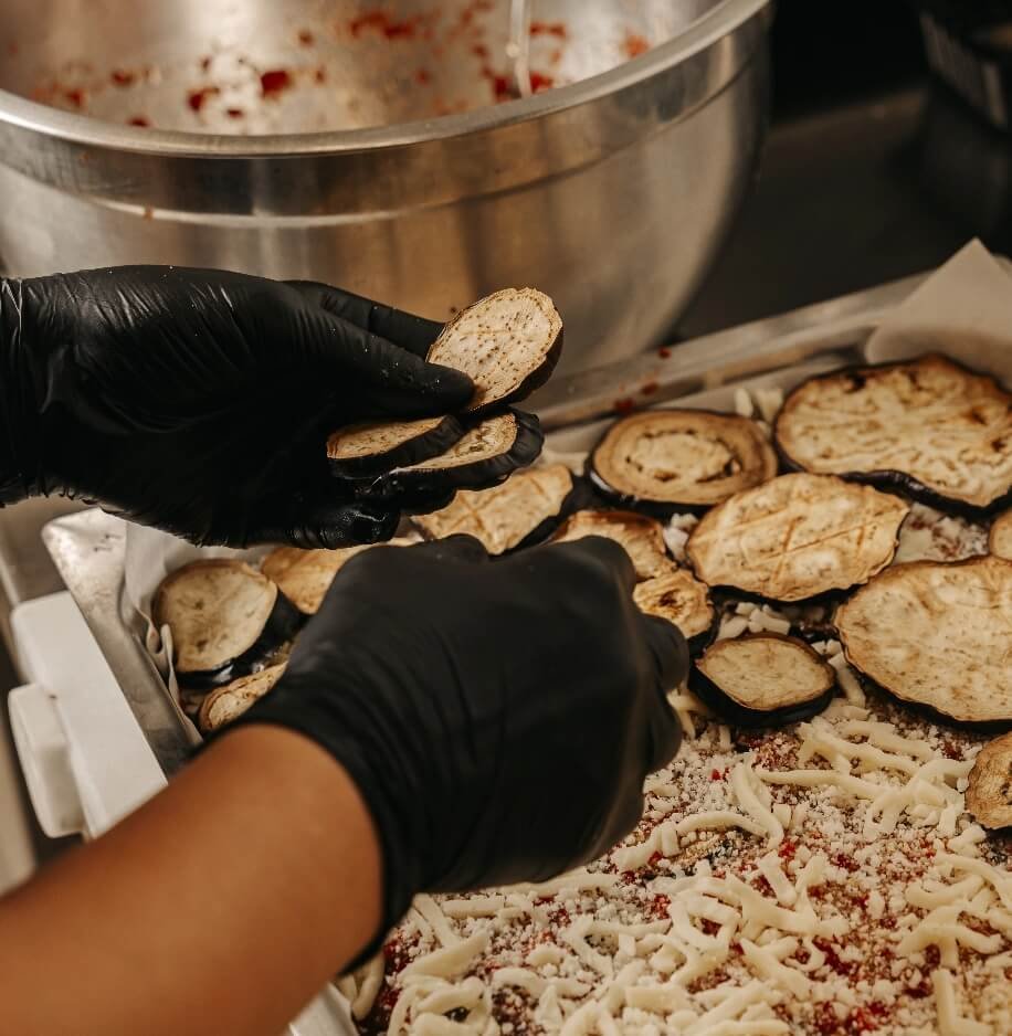 Preparazione della parmigiana di melanzane nel laboratorio Carlo Poma